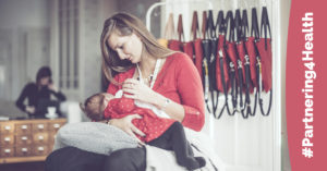 Mother breastfeeds infant in a semi-private, public place